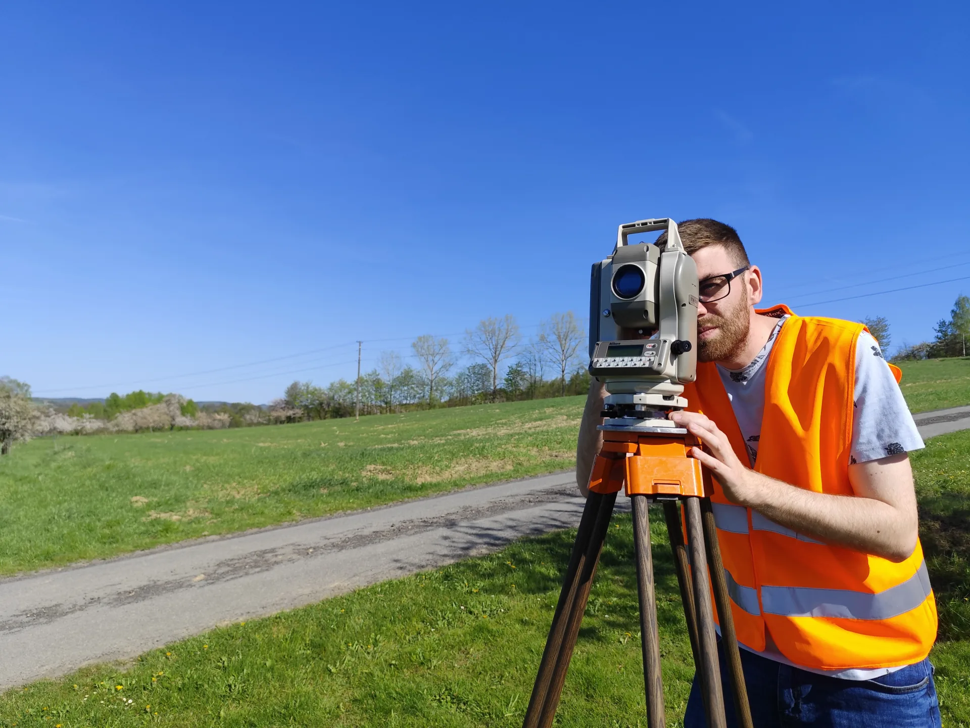 Geodeta GeoDuet wykonujący pomiar tachimetrem w terenie